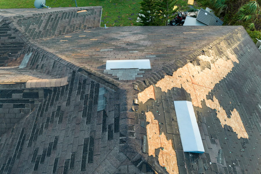 Damaged Roof With Missing Shingles on Suburban Home
