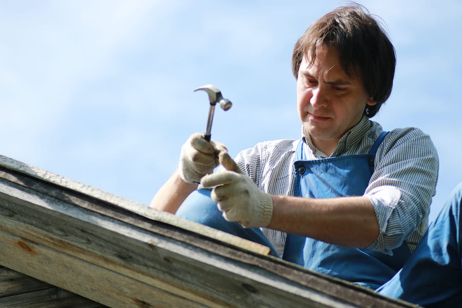 Amish roofing crew installing asphalt shingles on residential home