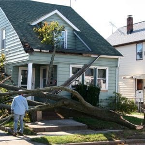 house with storm damage, tree down